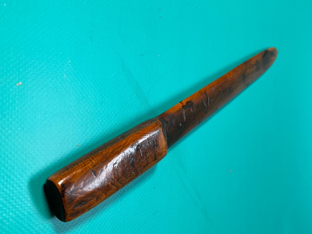 An antique hand-carved yew wood letter opener with a thick rounded handle tapering into a smooth blade. View XII