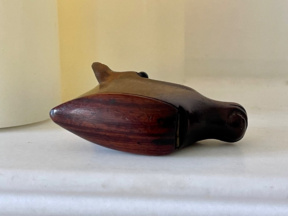 A hand-carved dark wood snuff box shaped in the detailed form of a horse head with a hinged opening at the base. View II