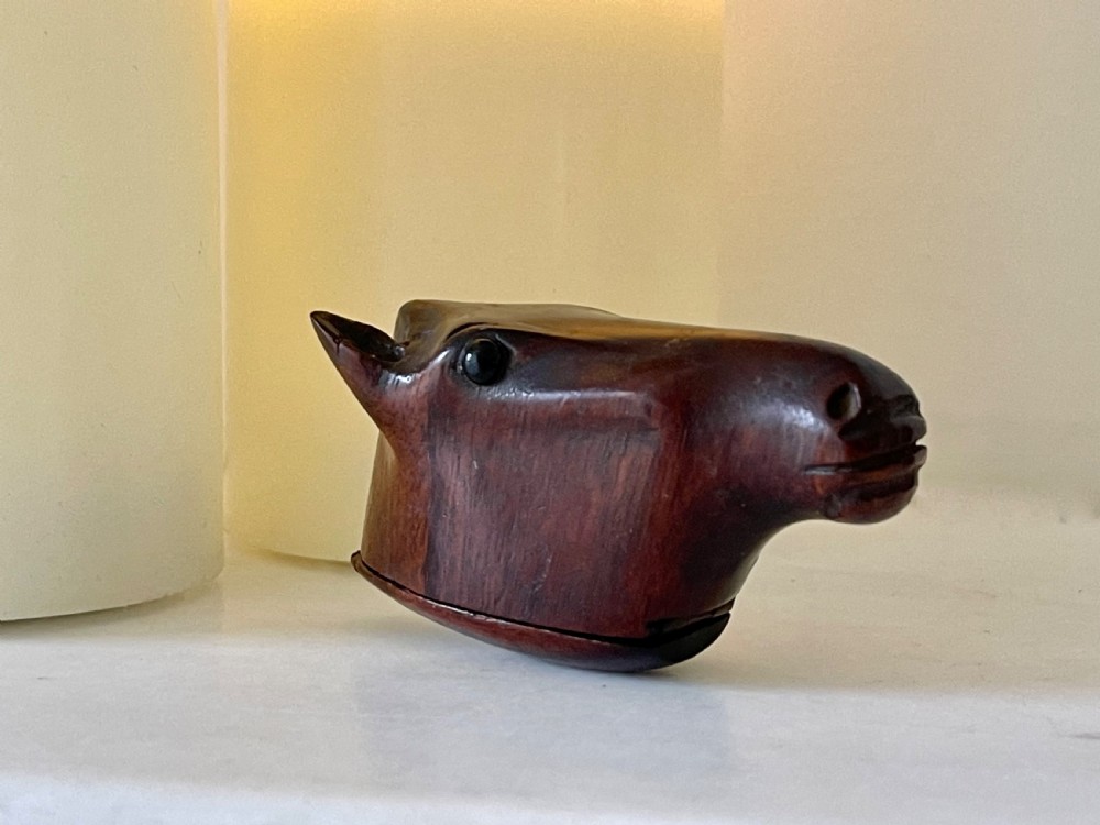 A hand-carved dark wood snuff box shaped in the detailed form of a horse head with a hinged opening at the base. View IV