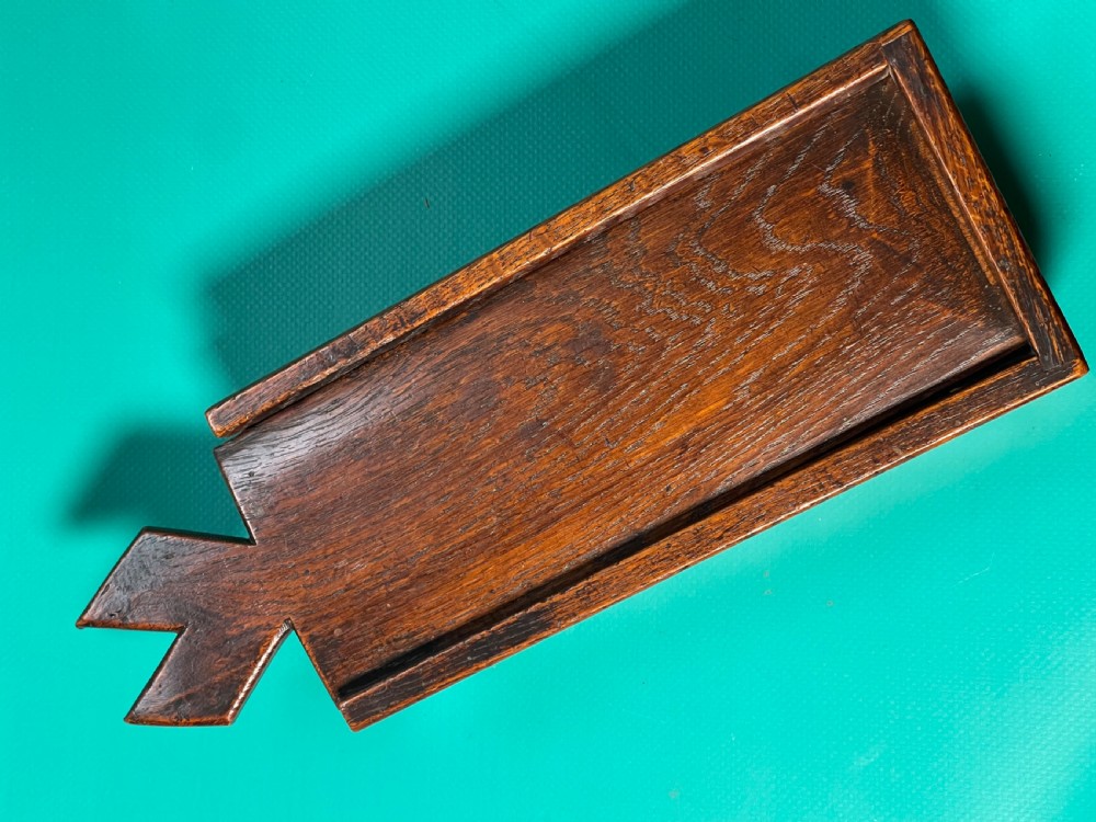 A dark carved oak tinder box with a sliding top lid and a shaped geometric end handle. View IV