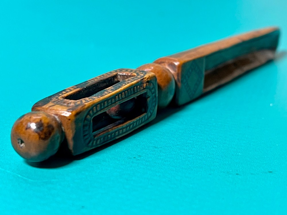 An 18th-century carved fruitwood treen apple corer with geometric incised details and a hollowed scoop. View II