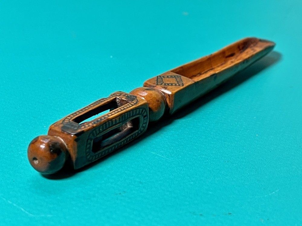 An 18th-century carved fruitwood treen apple corer with geometric incised details and a hollowed scoop. View V
