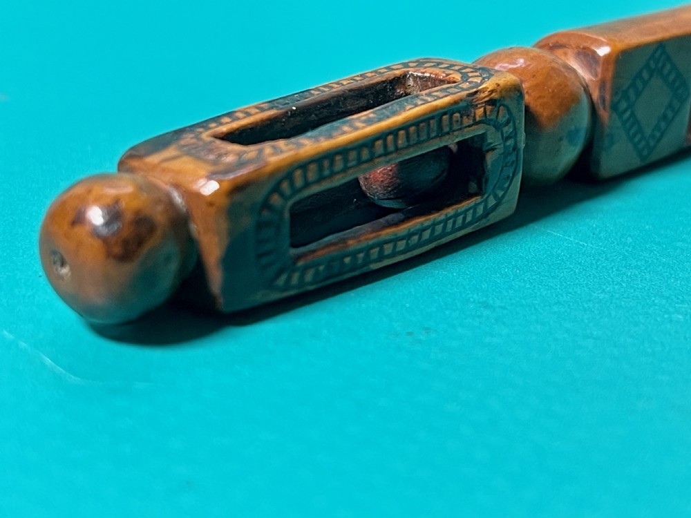 An 18th-century carved fruitwood treen apple corer with geometric incised details and a hollowed scoop. View VI