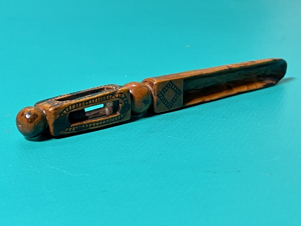 An 18th-century carved fruitwood treen apple corer with geometric incised details and a hollowed scoop. View VII
