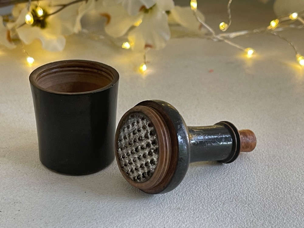 A small turned dark wood nutmeg grater shaped like a wine bottle with a wooden stopper top. View II