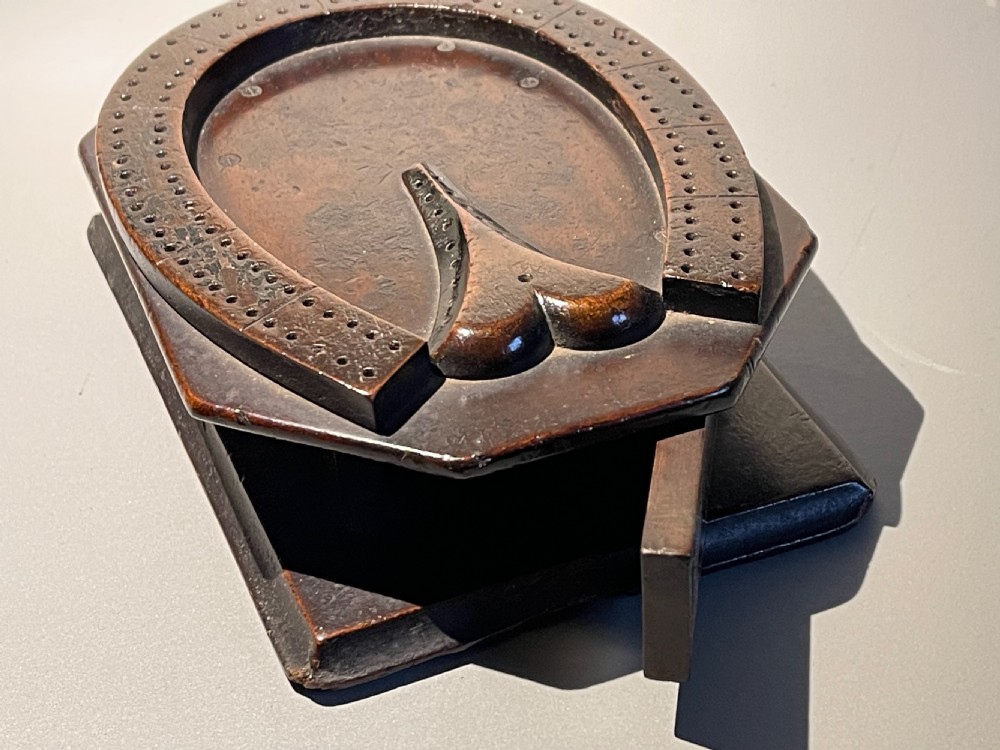 A dark brown carved wood horseshoe-shaped Georgian cribbage board mounted on a rectangular wooden box. View IV