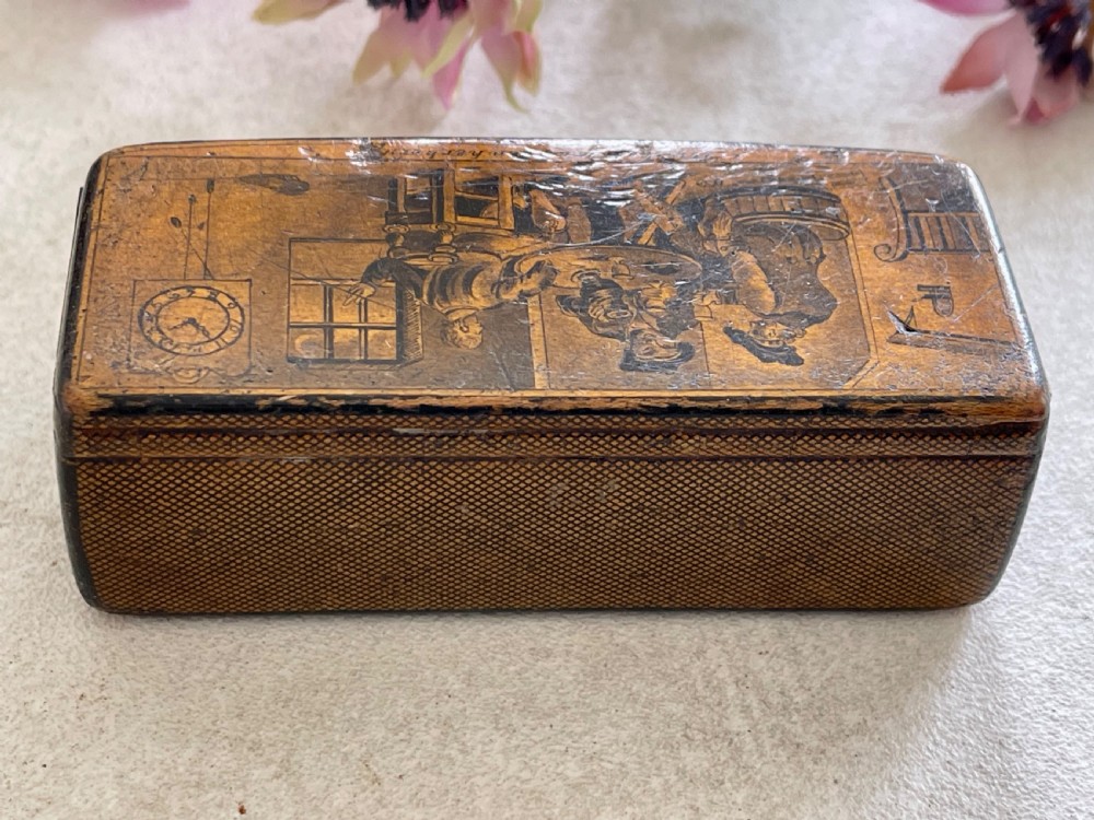 A small rectangular antique wooden snuff box featuring penwork illustrations of men in a tavern on the lid and a central name tag inscribed G. Cobb on the front. View VI