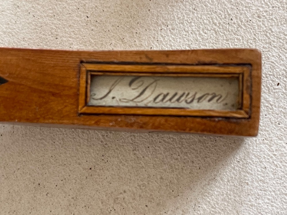 A curved antique wooden knitting sheath featuring geometric marquetry inlays and a small metal-ended aperture. View III