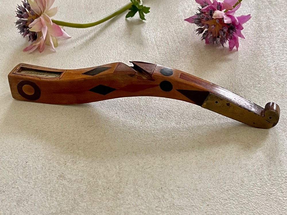 A curved antique wooden knitting sheath featuring geometric marquetry inlays and a small metal-ended aperture. View IV