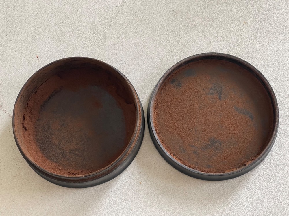 A circular black lacquered papier-mache snuff box lid featuring a hand-painted classical portrait of a bearded man wearing a green headband. View II