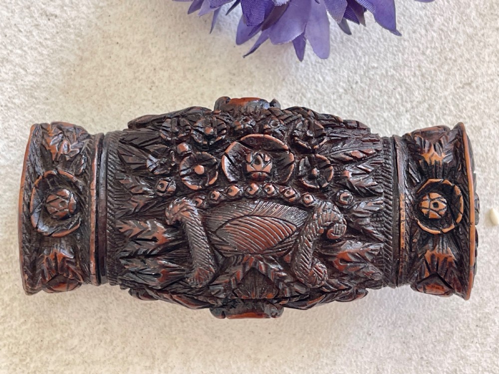 A detailed carved dark brown coquilla nut snuff box featuring a central relief medallion of a female profile surrounded by decorative foliage patterns. View II