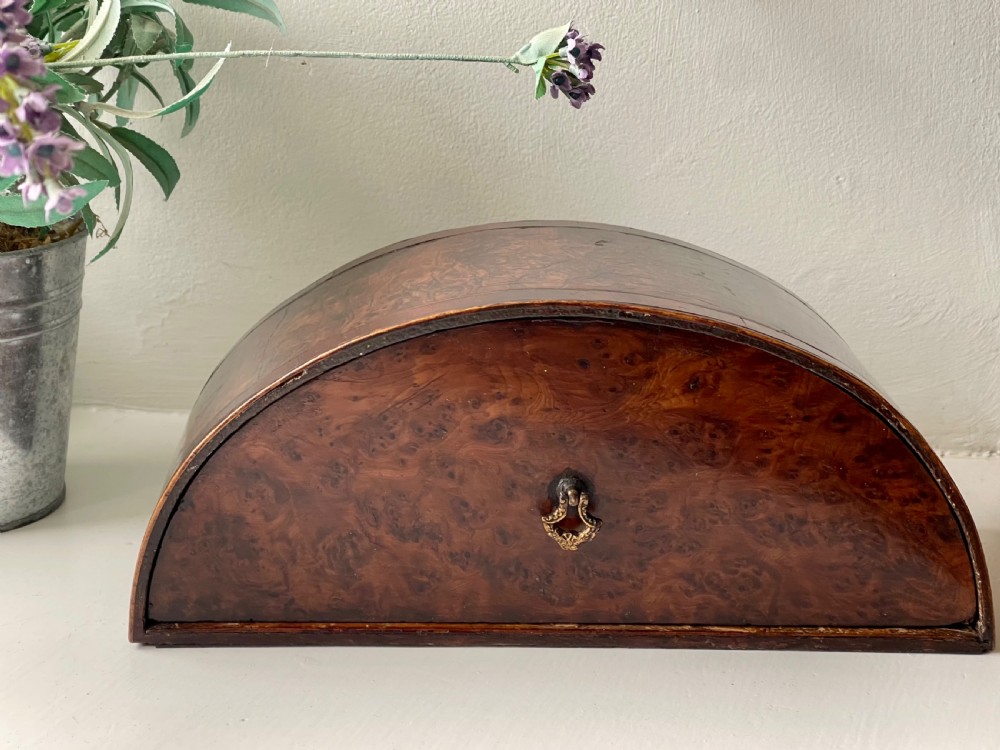 A Georgian semi-circular wooden box featuring highly figured burr wood veneer and a top brass finial. View II
