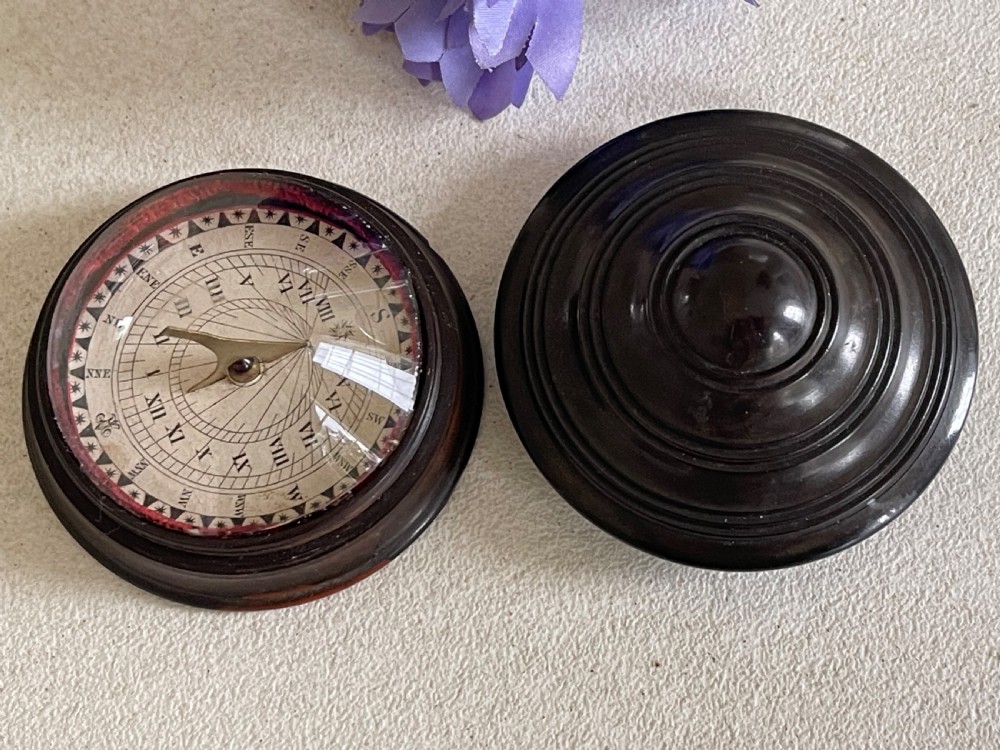A small, circular antique turned wood case with a domed, stepped lid designed to hold a travelling compass sundial. View II