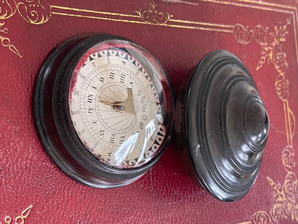 A small, circular antique turned wood case with a domed, stepped lid designed to hold a travelling compass sundial. View III