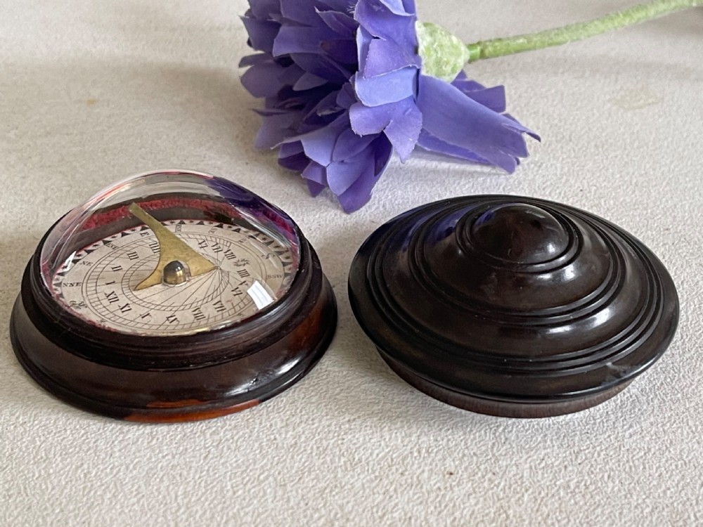 A small, circular antique turned wood case with a domed, stepped lid designed to hold a travelling compass sundial. View IV