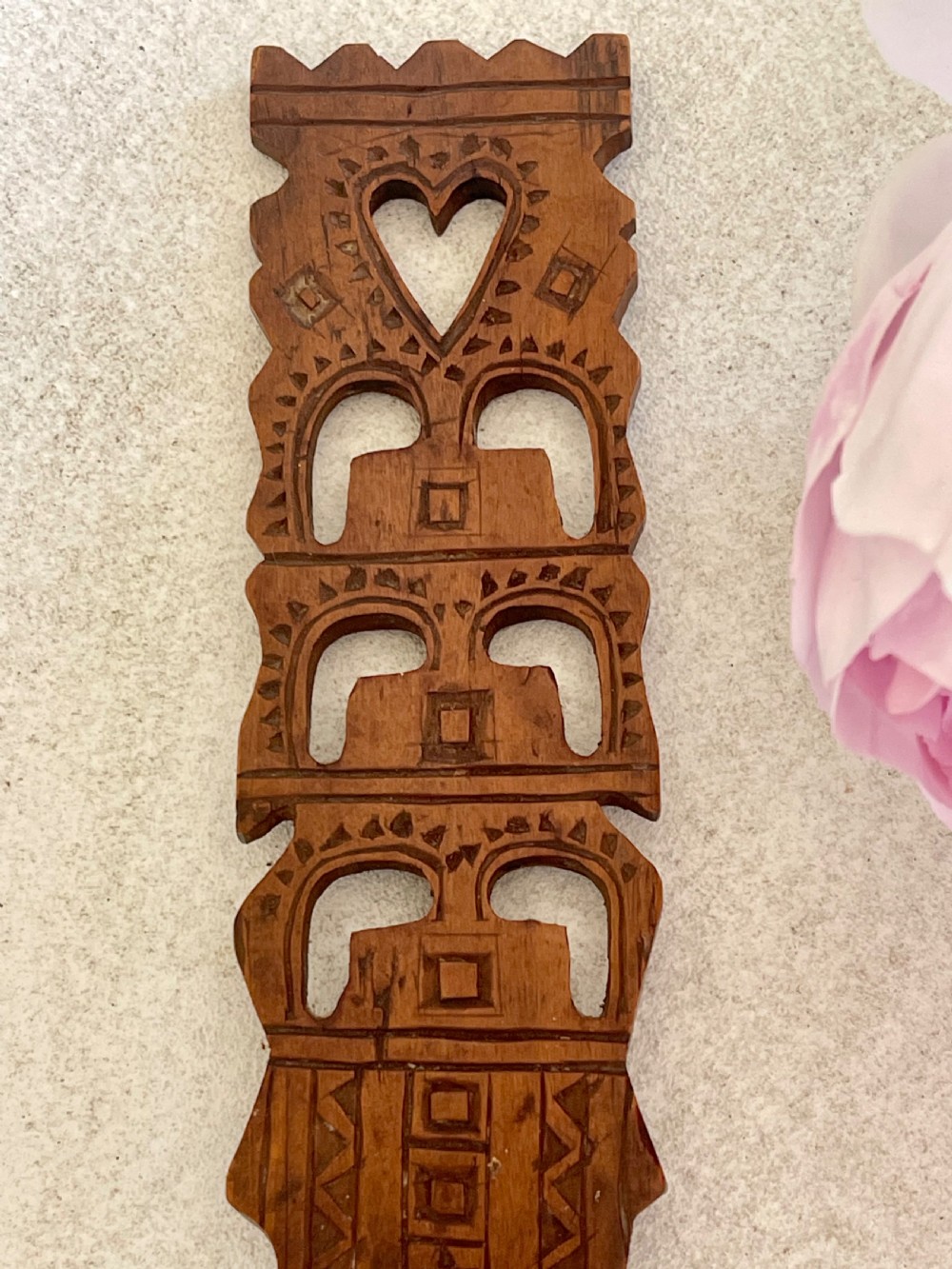 A hand-carved dark wood Welsh lovespoon with geometric chip-carved detailing, a pierced heart cutout at the top, and a smoothed spoon bowl. View IV