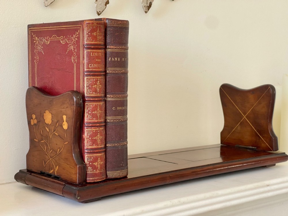 An antique Victorian Irish Killarney arbutus wood book slide featuring inlaid floral marquetry and folding hinged ends.