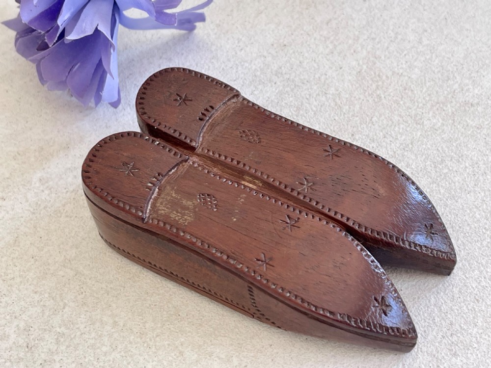 A carved brown wooden double shoe-shaped snuff box featuring stippled geometric patterns, metal spring hinges, and an inset oval miniature portrait of a lady on top. View III