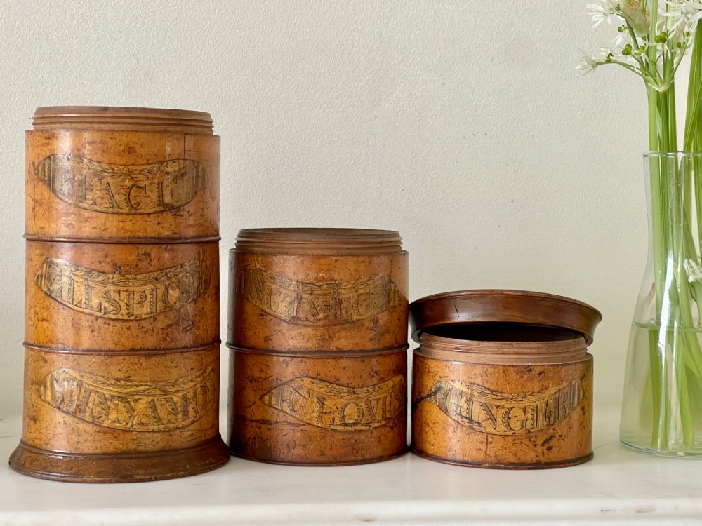 A tall, lathe-turned wooden six-tier cylindrical spice tower featuring original paper labels on each section. View II