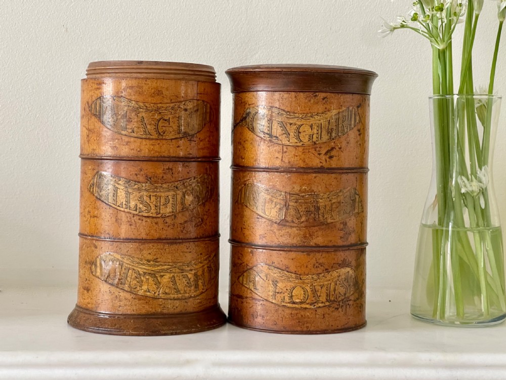 A tall, lathe-turned wooden six-tier cylindrical spice tower featuring original paper labels on each section. View V