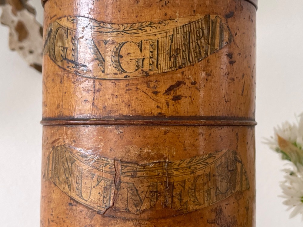 A tall, lathe-turned wooden six-tier cylindrical spice tower featuring original paper labels on each section. View VI