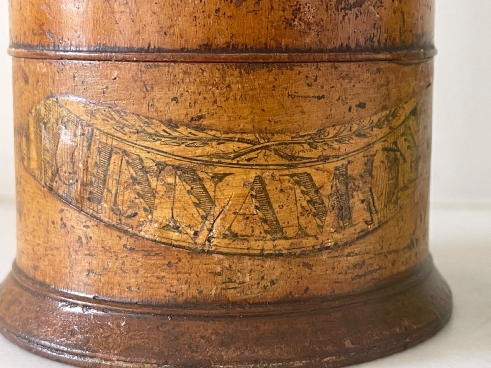 A tall, lathe-turned wooden six-tier cylindrical spice tower featuring original paper labels on each section. View VII