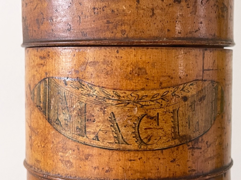 A tall, lathe-turned wooden six-tier cylindrical spice tower featuring original paper labels on each section. View VIII