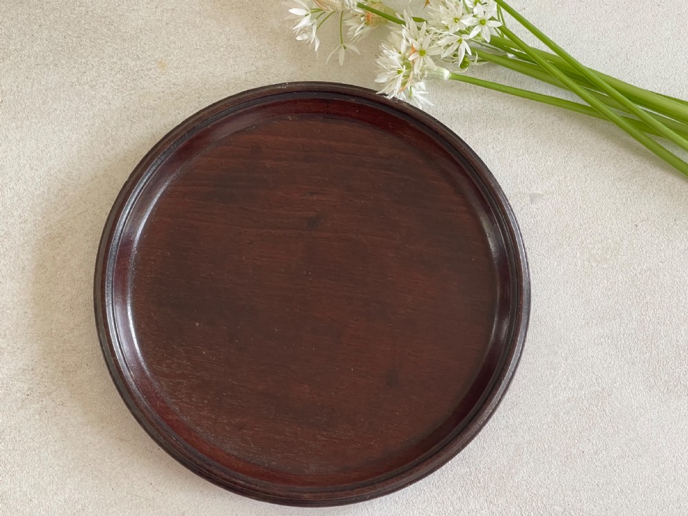 A small circular Georgian mahogany card tray featuring a raised moulded rim and dark reddish-brown wood grain.