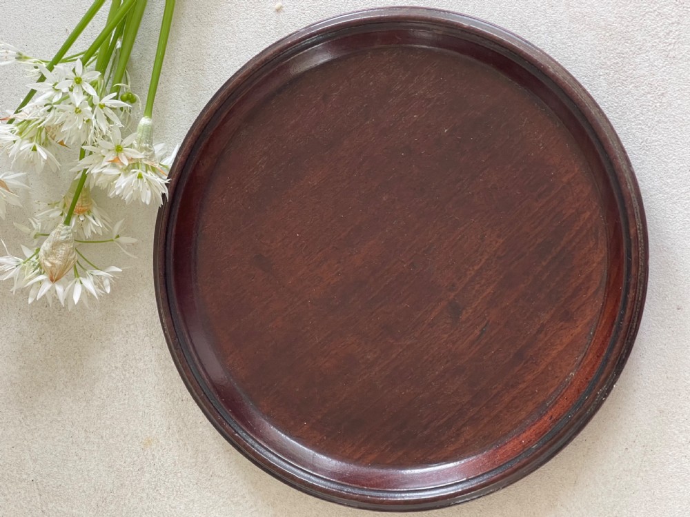 A small circular Georgian mahogany card tray featuring a raised moulded rim and dark reddish-brown wood grain. View II