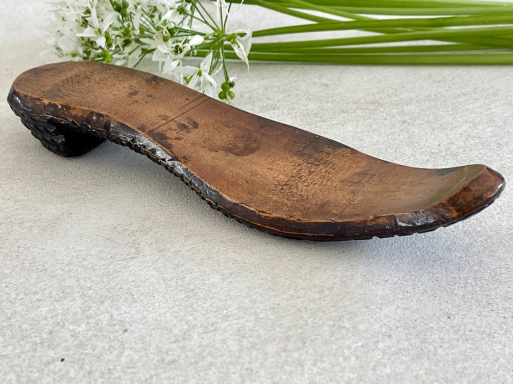 A carved wooden knitting sheath crafted in the shape of a shoe sole with a polished dark surface. View VII