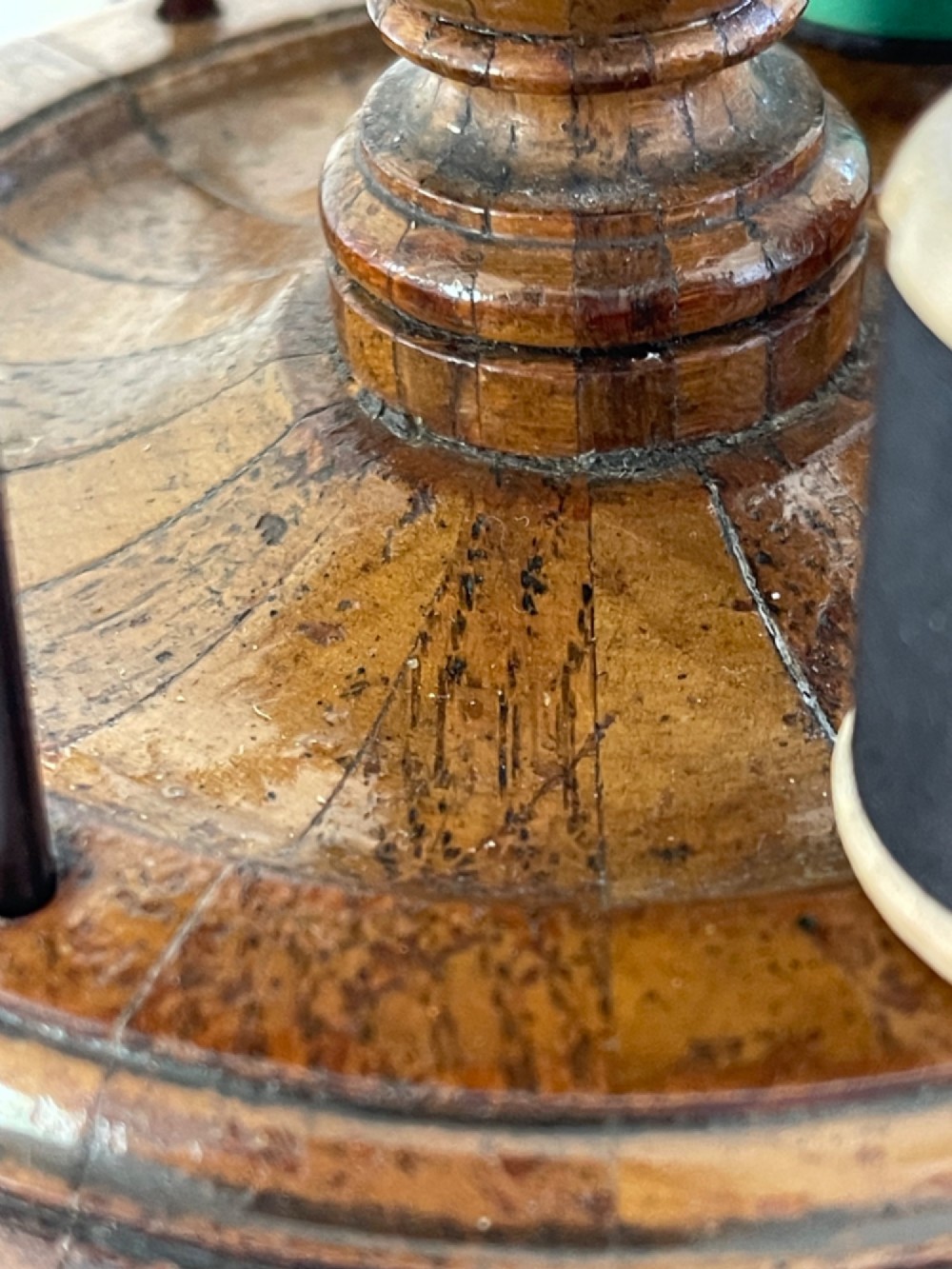 A multi-tiered turned wooden cotton reel stand with vertical metal spindles holding coloured spools of thread on bun feet. View V