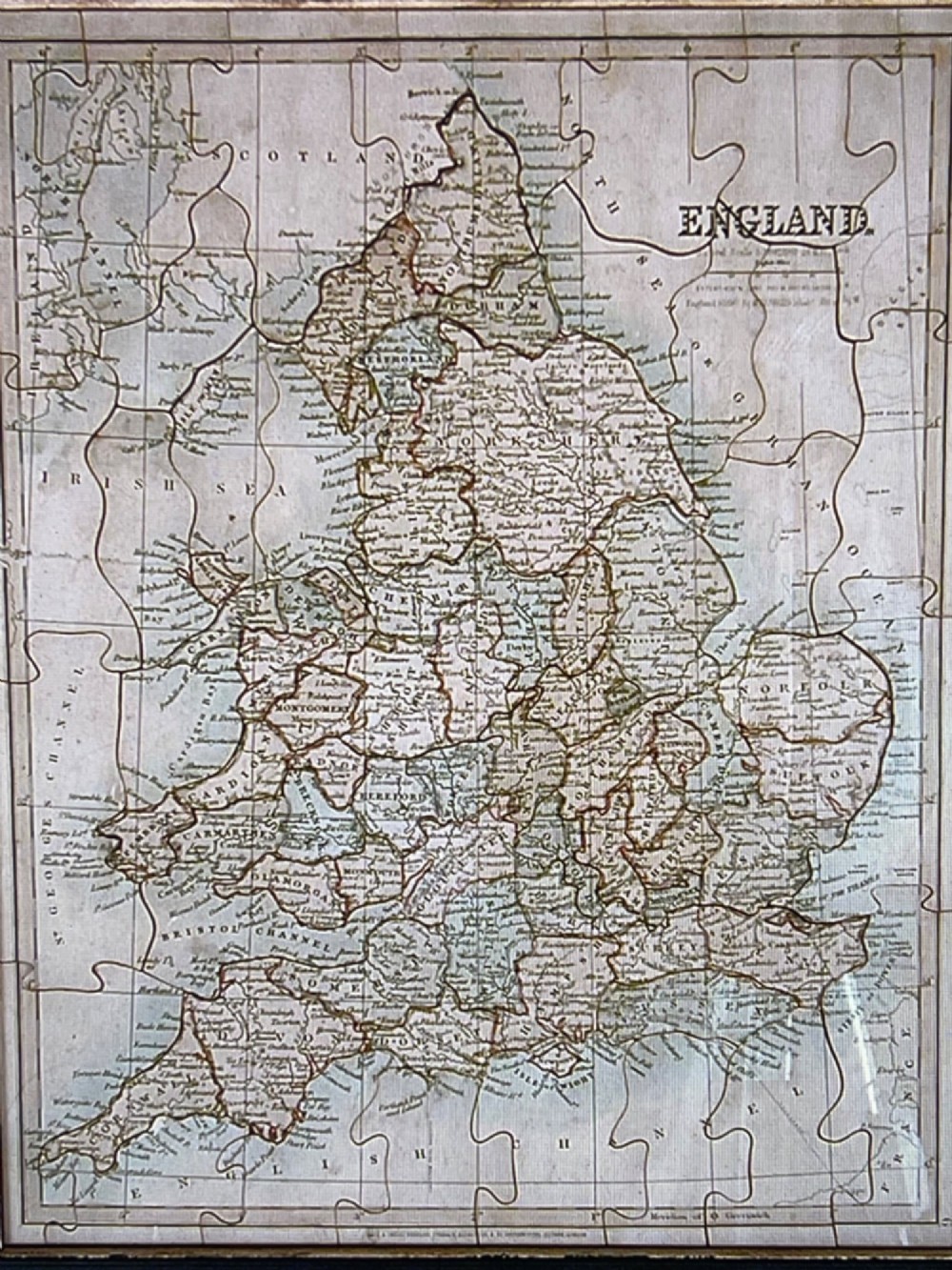An antique wooden box featuring a printed paper label titled Peacocks New Double Dissection Geography and History England and Wales with illustrations of a globe, historical figures, and coat of arms. View IV