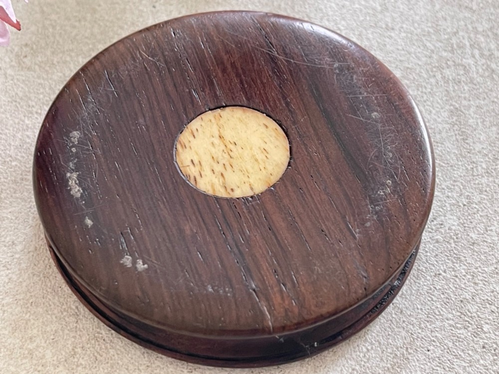 A circular antique wooden snuff box with a lid inlaid in a geometric tumbling block parquetry pattern. View II