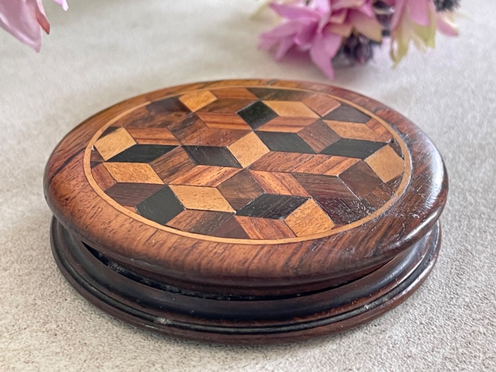A circular antique wooden snuff box with a lid inlaid in a geometric tumbling block parquetry pattern. View VI