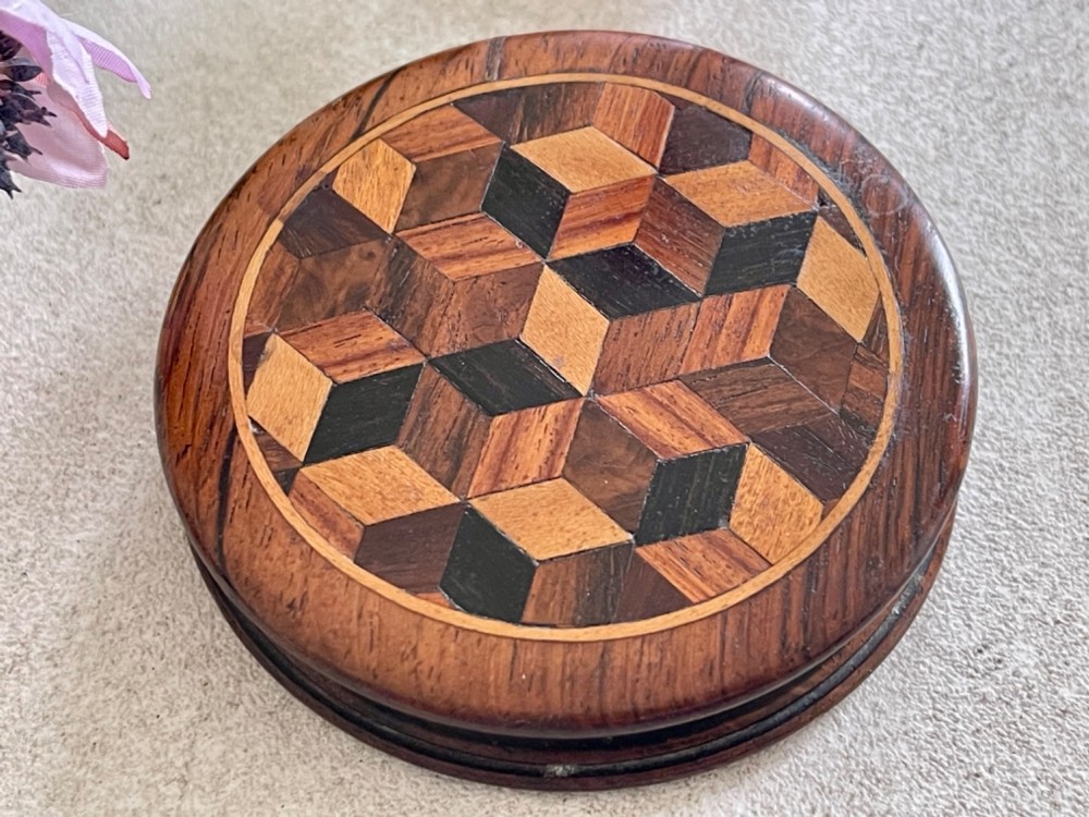 A circular antique wooden snuff box with a lid inlaid in a geometric tumbling block parquetry pattern. View VII