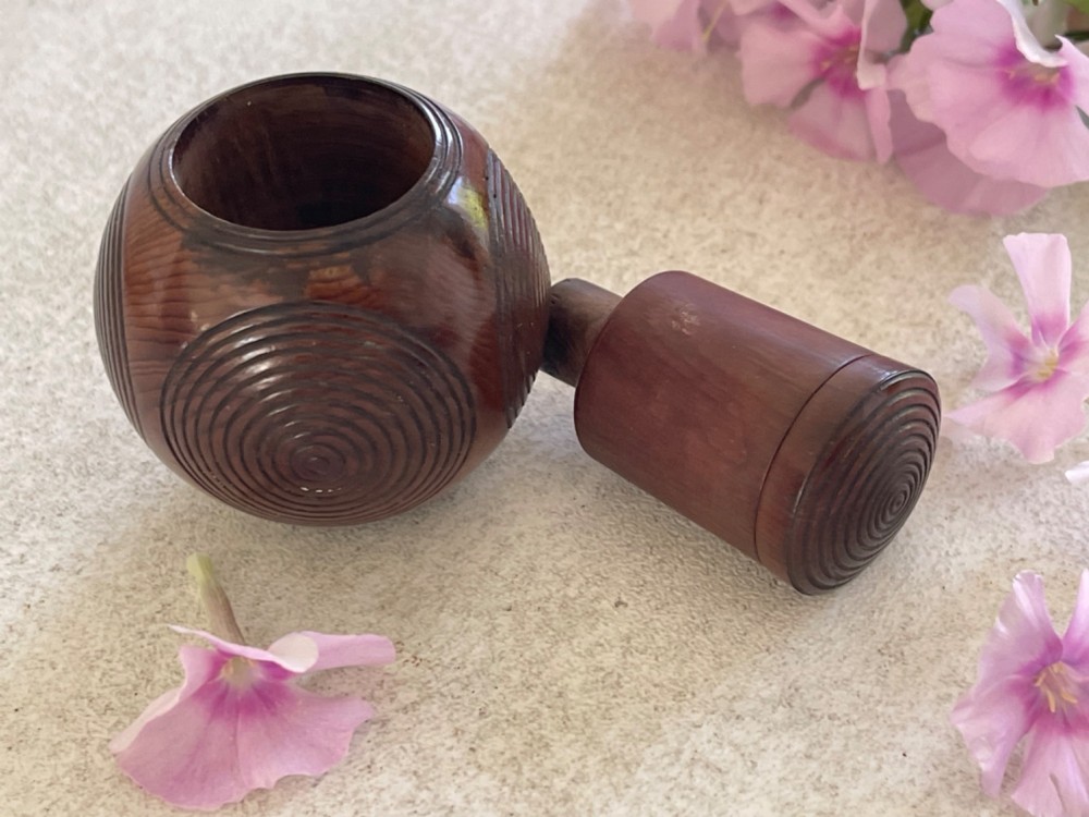 A spherical carved dark brown wooden puzzle ball featuring concentric circular grooves on its outer surface. View II