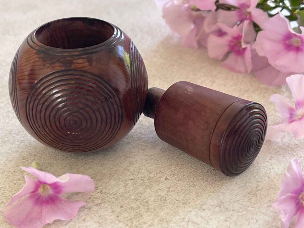 A spherical carved dark brown wooden puzzle ball featuring concentric circular grooves on its outer surface. View IV