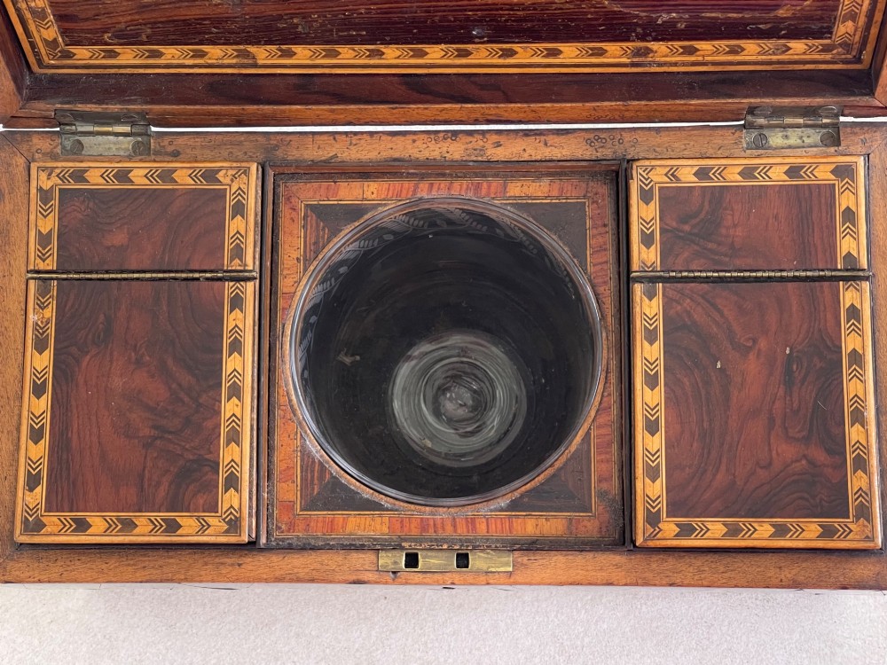 A rectangular Georgian wooden tea caddy featuring geometric triangular parquetry inlay across the front facade and a bevelled lid with a keyhole escutcheon. View II