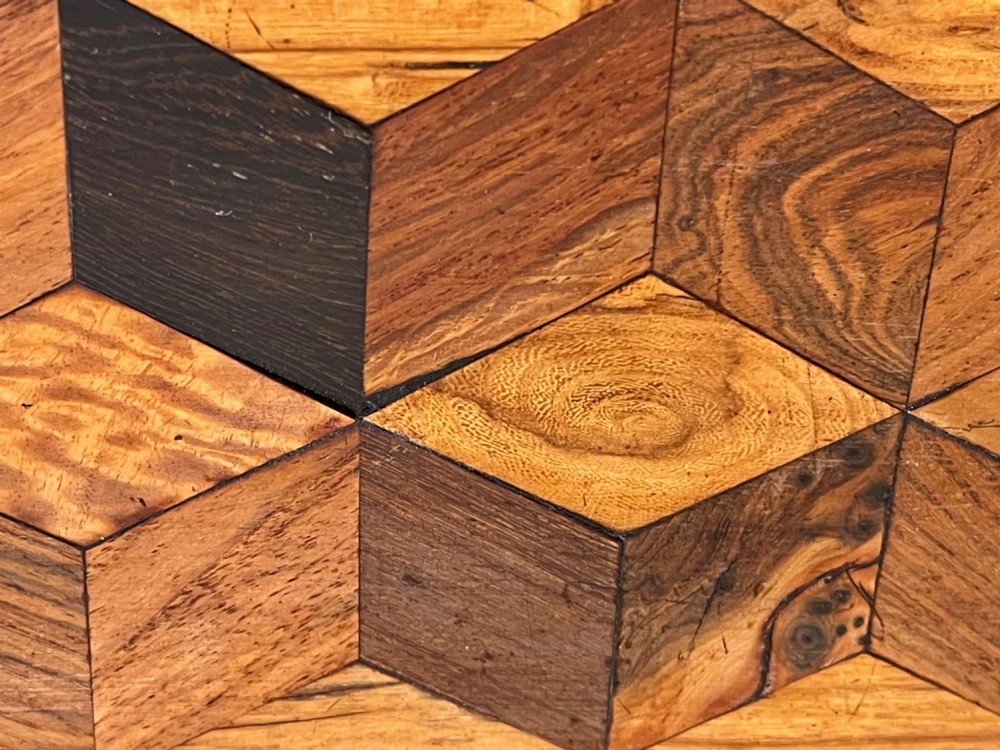 A rectangular Georgian wooden tea caddy featuring geometric triangular parquetry inlay across the front facade and a bevelled lid with a keyhole escutcheon. View V