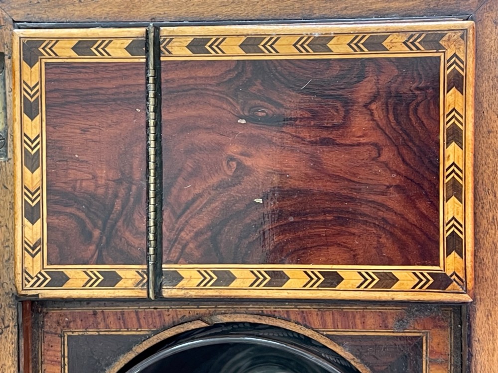 A rectangular Georgian wooden tea caddy featuring geometric triangular parquetry inlay across the front facade and a bevelled lid with a keyhole escutcheon. View X