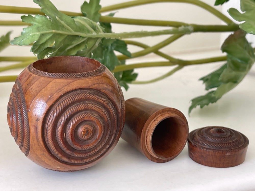 A spherical turned wood puzzle ball featuring concentric carved rope twist rings and visible timber grain patterns. View II