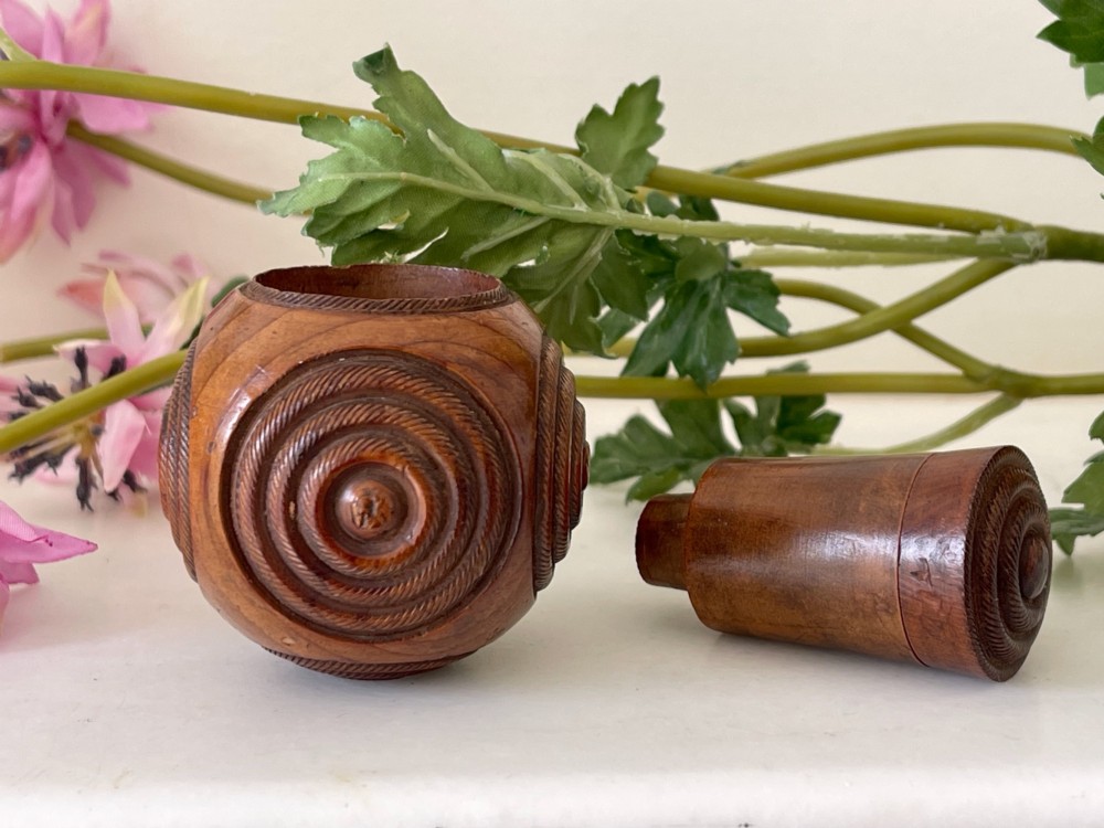 A spherical turned wood puzzle ball featuring concentric carved rope twist rings and visible timber grain patterns. View III