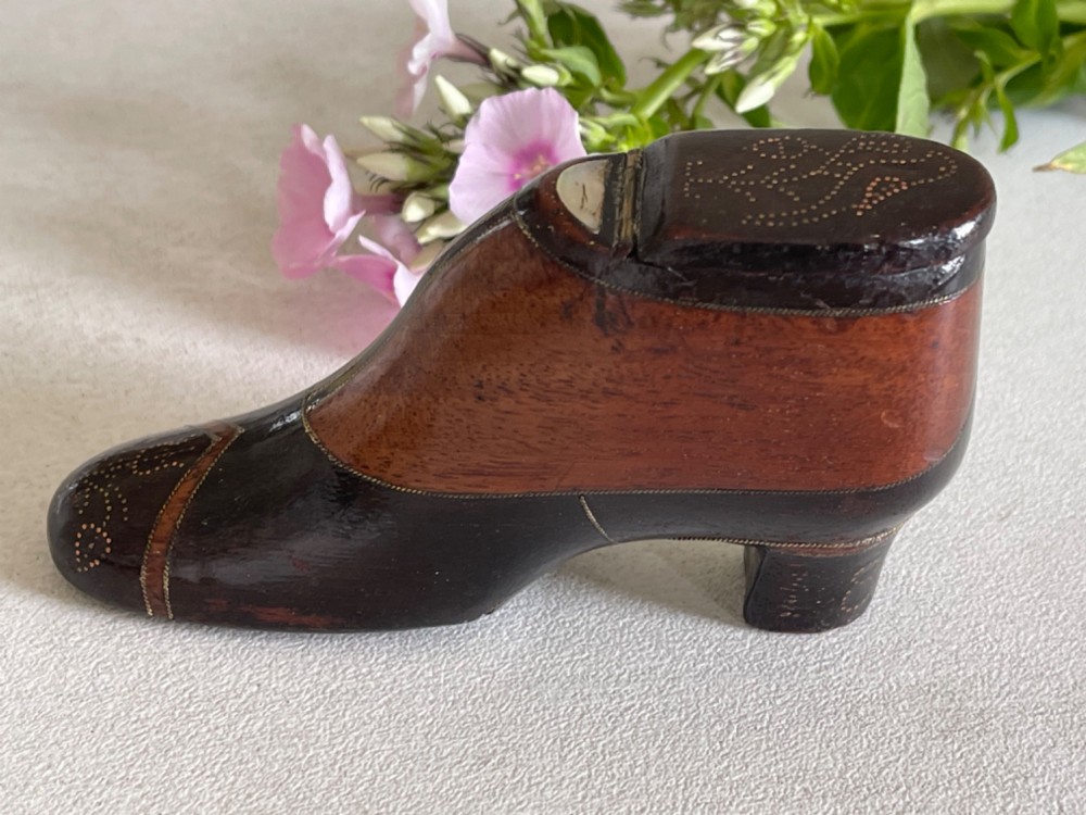 A carved wooden snuff box crafted in the shape of a high-heeled shoe featuring brass pin decoration and double compartments. View II
