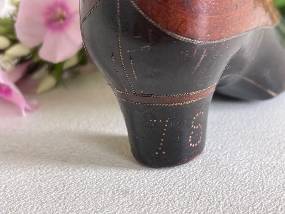 A carved wooden snuff box crafted in the shape of a high-heeled shoe featuring brass pin decoration and double compartments. View III