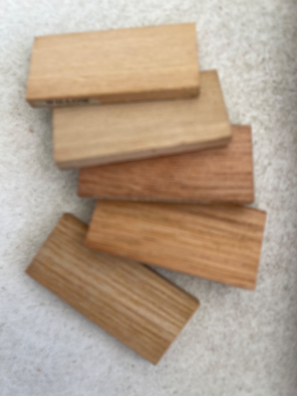 An open rectangular wooden presentation box containing labelled timber sample slats from an early twentieth century London wood merchant. View V