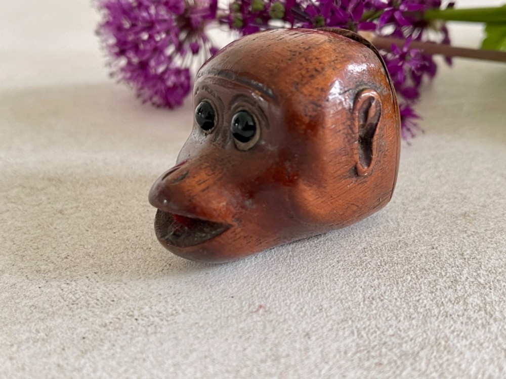 A carved wooden snuff box in the form of a monkey head with inset black glass eyes. View II