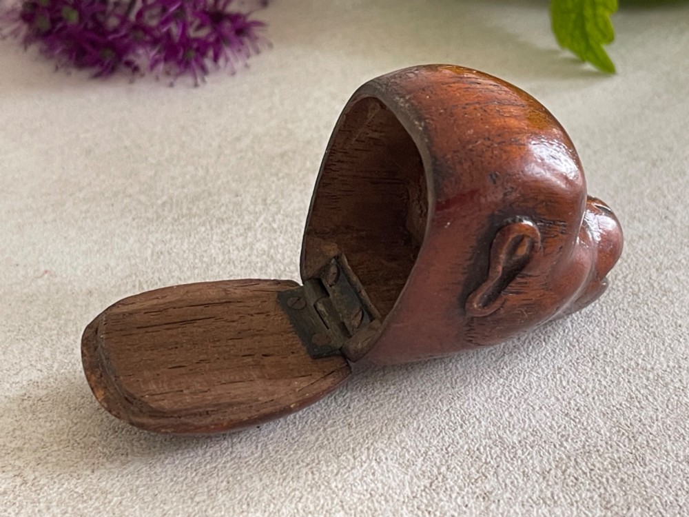A carved wooden snuff box in the form of a monkey head with inset black glass eyes. View III