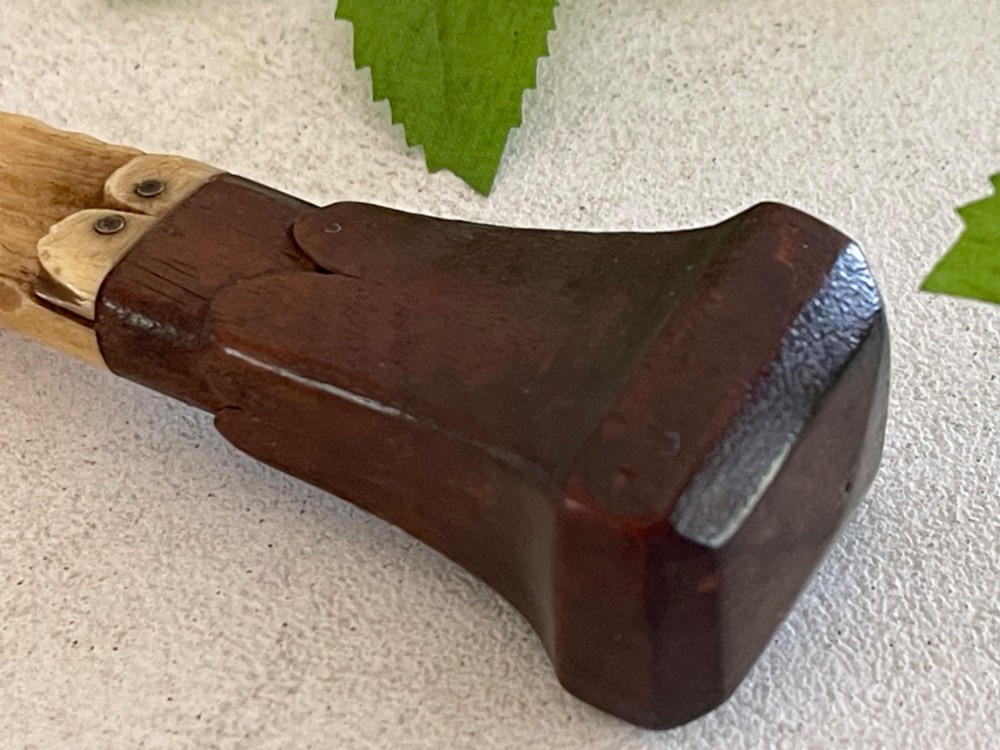 A Georgian treen apple corer featuring a dark mahogany handle joined to a carved bone scoop with metal pins. View II