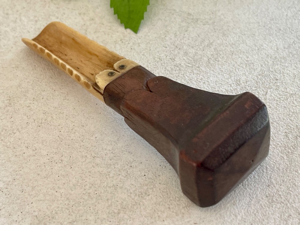A Georgian treen apple corer featuring a dark mahogany handle joined to a carved bone scoop with metal pins. View III