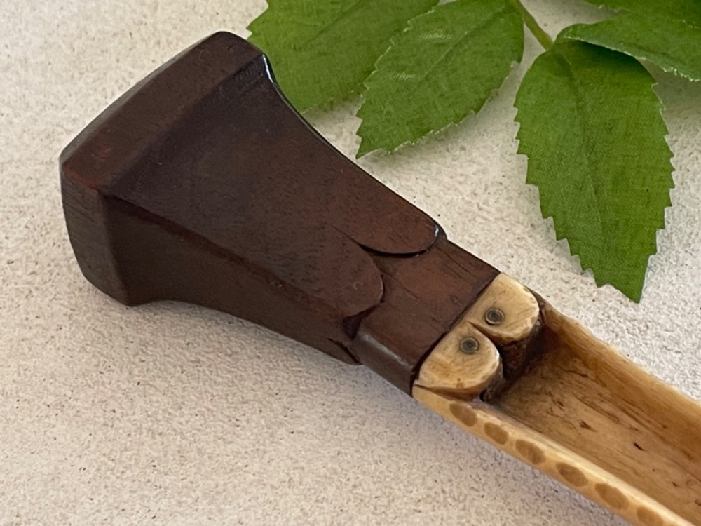 A Georgian treen apple corer featuring a dark mahogany handle joined to a carved bone scoop with metal pins. View V